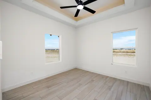 Bedroom with an LED tray ceiling and a wood-look plank floor
