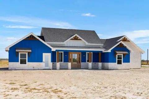 Blue board and batten ranch home with white stone, cedar trim and a gray shingle roof