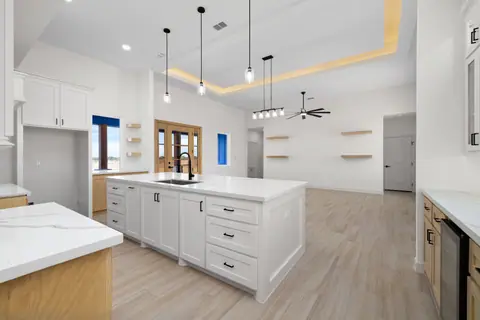 Kitchen island and prep counter with marble-look tops and pendant lights