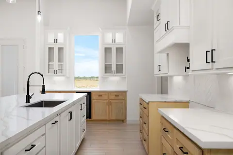 Island sink with a black faucet and a herringbone tile backsplash