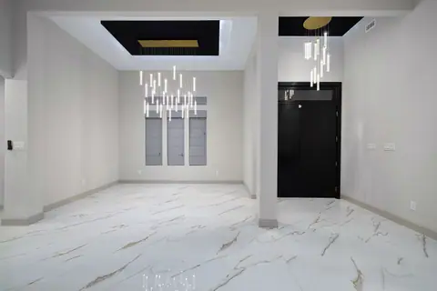 Dining area with a cascading light fixture and a black tray ceiling