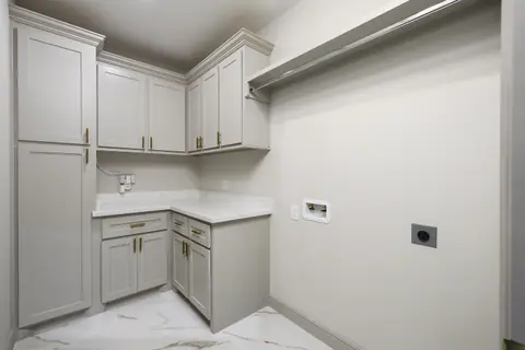 Laundry room with gray shaker cabinets and a white counter