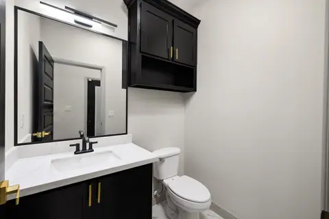 Half bath with a black vanity and a matching wall cabinet