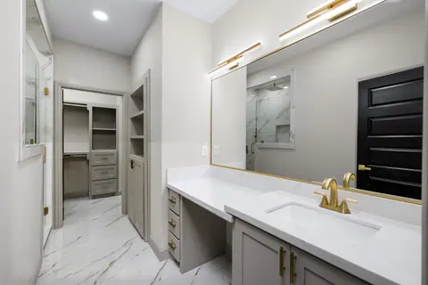 Vanity with a gold-framed mirror, a makeup counter and closet access