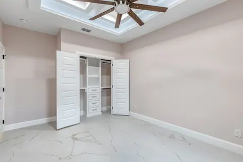 Bedroom closet with built-in drawers and shelving behind double doors