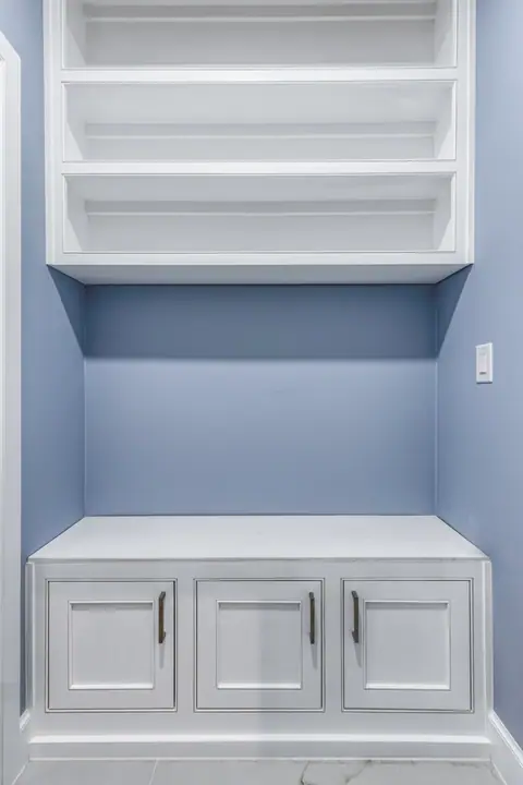 Built-in bench cabinet with open shelves in a blue bedroom