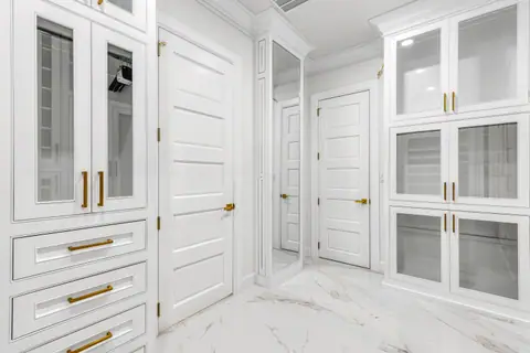 Clóset vestidor con espejo de cuerpo completo, gabinetes de vidrio y puertas de tablero