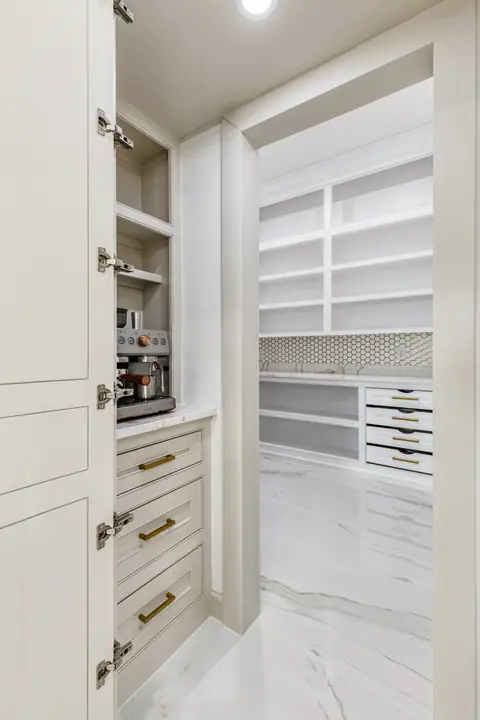 Appliance cabinet with a coffee station beside the walk-in pantry