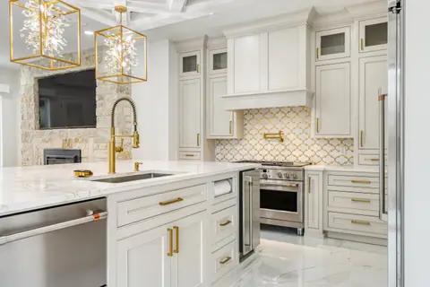 Island sink with a gold pull-down faucet, facing the living room fireplace