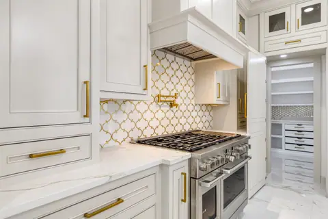 Pared de la estufa con azulejo arabesco dorado, llave para ollas y campana a la medida