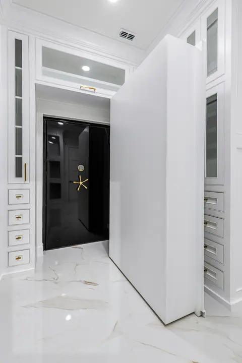 Hidden closet panel opening onto a black safe room door