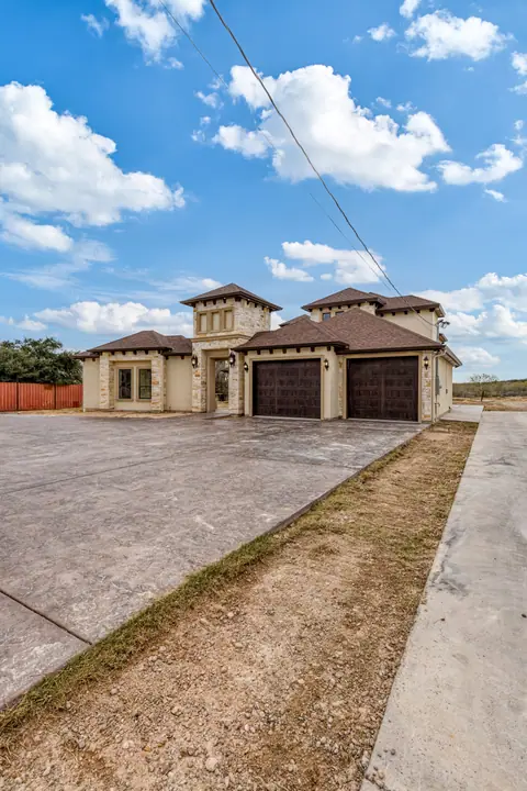 Entrada de concreto estampado y banqueta junto a una casa de stucco