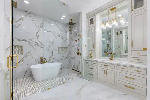 Frameless glass wet room and a vanity with crystal lights and gold fixtures