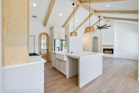 Kitchen island with a farmhouse sink facing a linear fireplace