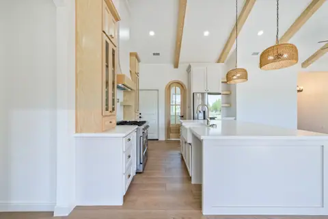 View down the island to an arched wood pantry door